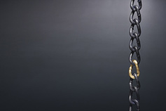 chain with gold link on black wall