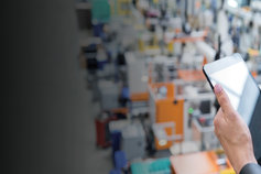 hand holding tablet on a blurred grey background