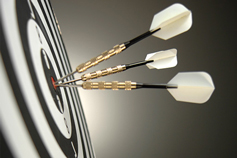 Black and white darts hitting the bulls-eye