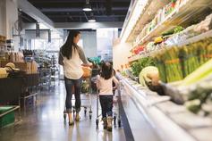 Asian woman grocery shopping with young daughter