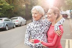 Two women on side of road smiling in the sunshine