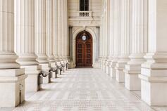 Marble columns and wooden door entrance to beautiful building