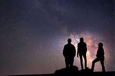 3 people standing under sky in night, stars