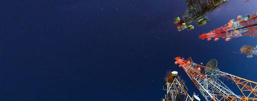 Telecom towers standing high below blue sky
