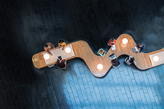 Panoramic overhead view of several business meetings going over curvy table