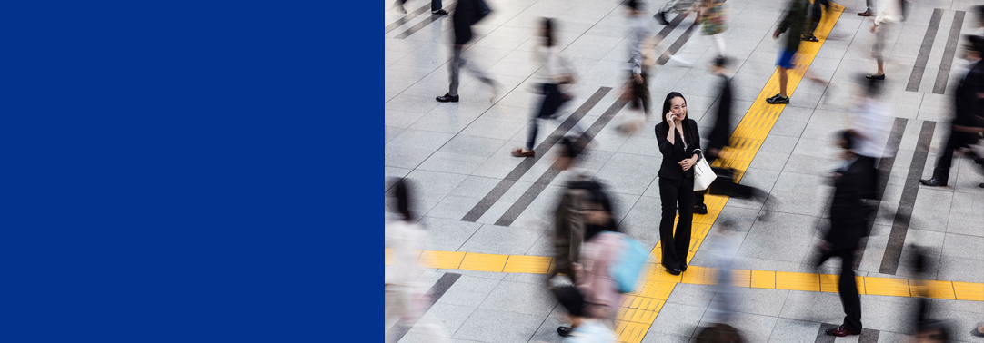 Woman talking over phone in crowd standing on yellow tiles