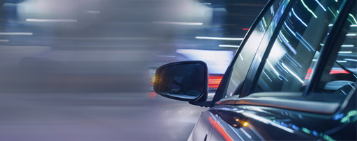 Car side mirror at night with light reflection on window glass