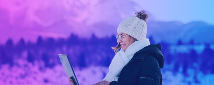Mujer con laptop en montaña nevada