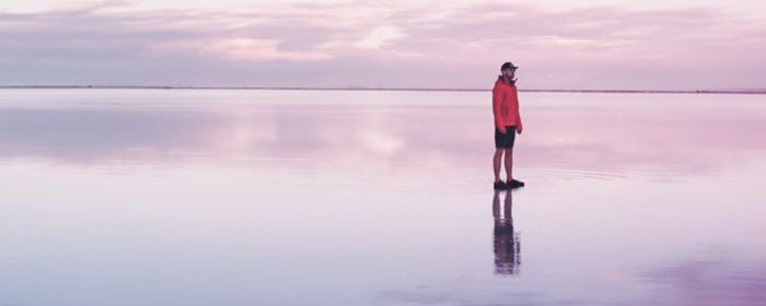 Hombre mirando hacia el horizonte en una playa