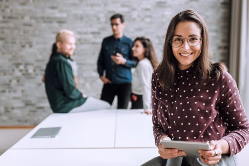 Mujer sonriente con una mesa en la oficina