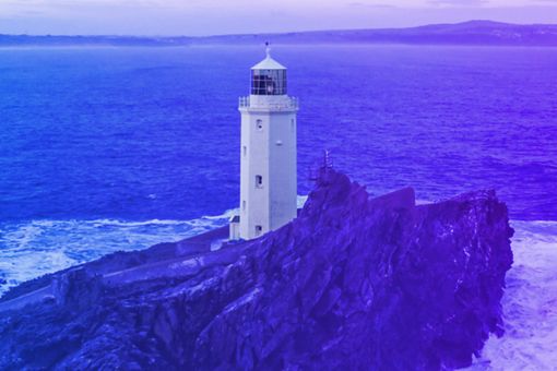 Faro de luz a la orilla del mar. El fondo es un degradado de purpura a azul cobalto