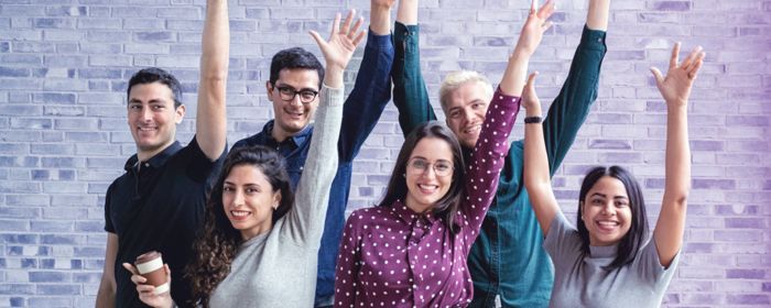 Equipo celebrando con las manos alzadas