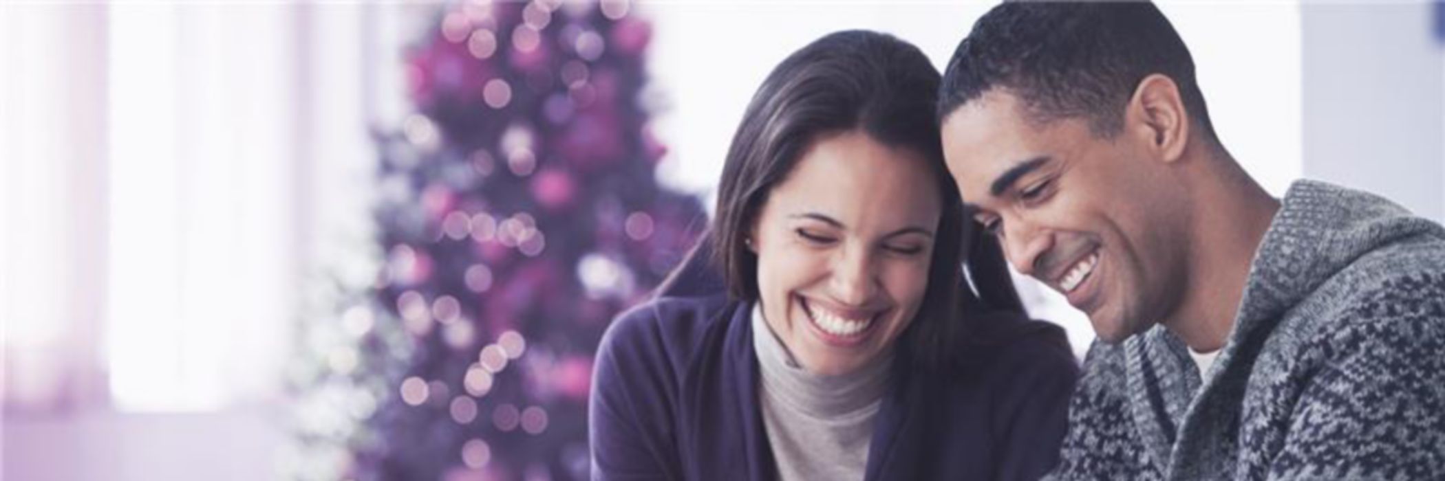 Pareja joven comprando con tarjeta de crédito en navidad