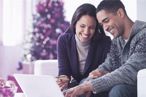 Pareja joven comprando con tarjeta de crédito en navidad