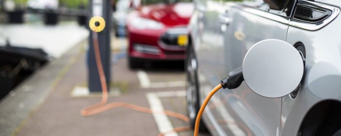 charger plugged into car parked next to canal