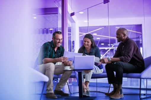 Casual meeting of smiling diverse business team analyzing financial data