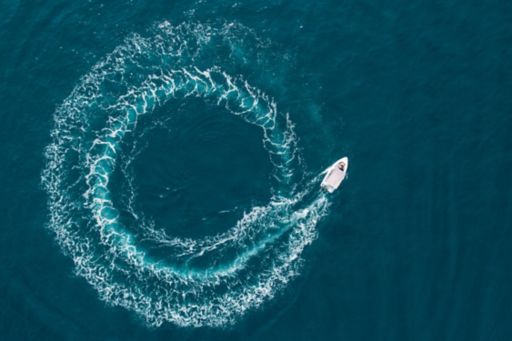 aerial view of a boat driving in circles in the ocean