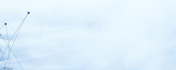 Oversiktsbilde over et alpinanlegg med snø og skyer