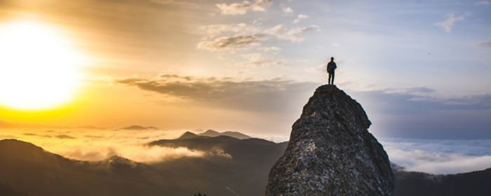 Man looking out from top of a mountain.