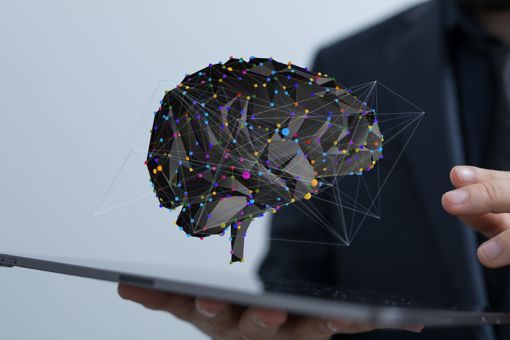 A 3D rendering of digital brain in front of a male holding tablet