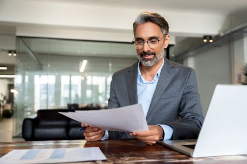 A man is holding a document at the office