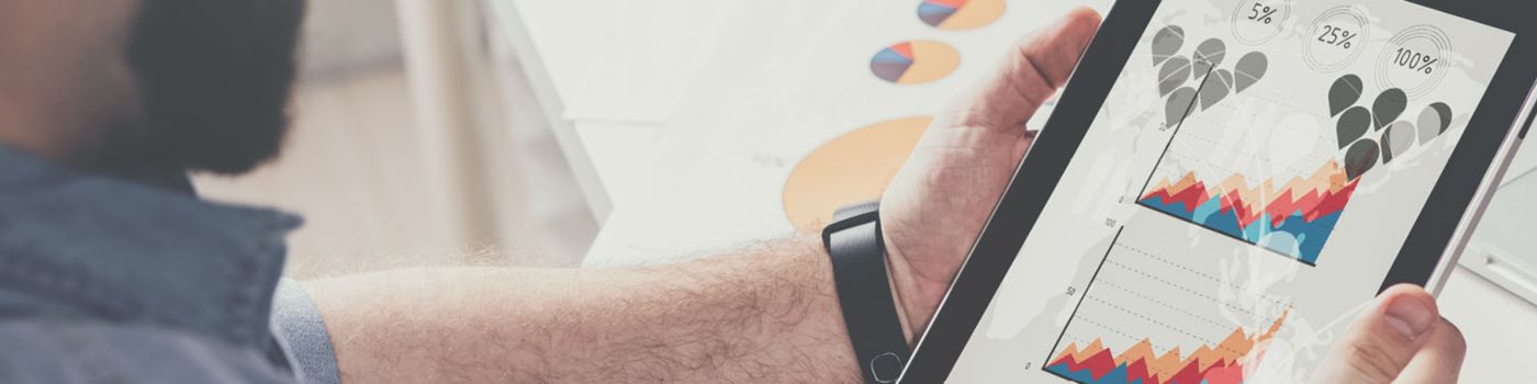 Man looking at graphs on a tablet