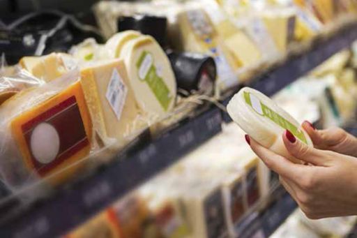 woman checking the product label of cheese in the supermarket