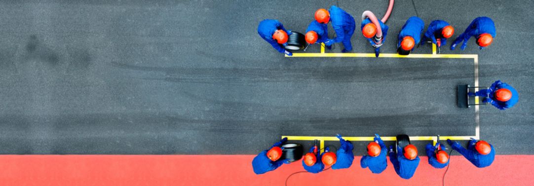 A pit crew mobilized for action on a race track