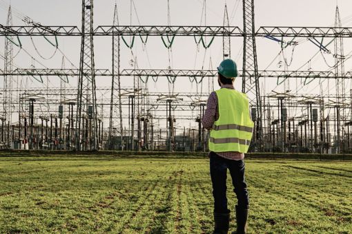 Man in hard hat standing in front of power lines