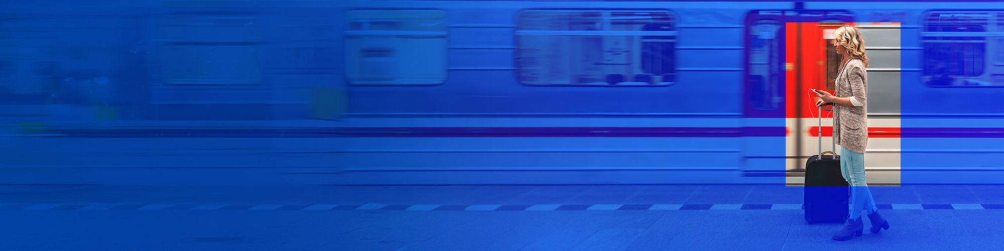 Lady holding suitcase standing outside moving train