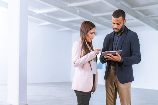 Empresaria asiática hablando con empresario en una oficina vacía