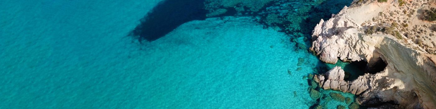 Birds-eye view of cliffs and clear blue-turquoise water