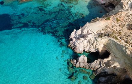 Birds-eye view of cliffs and clear blue-turquoise water
