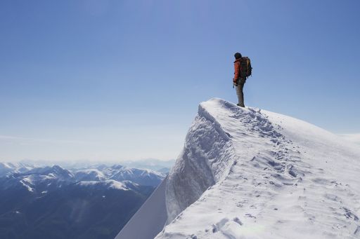 KPMG 'The future of IFRS' topic image (IASB agenda consultation): Climber on summit of snow capped mountain.