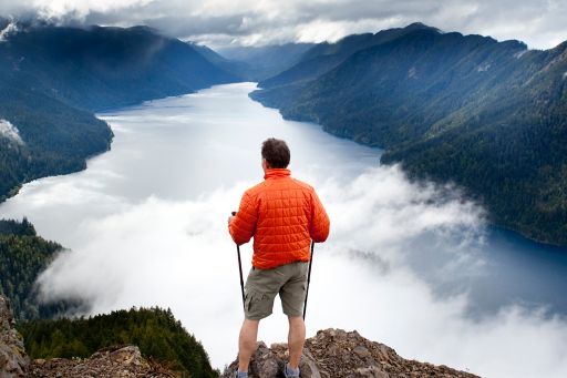 KPMG IFRS Business Combinations topic image: hiker looking down at clouds over a lake.
