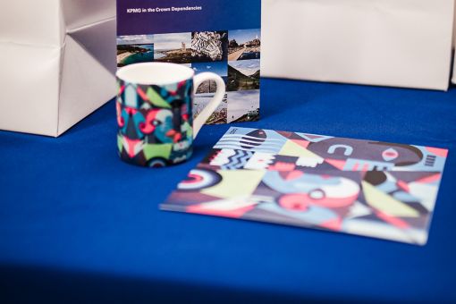 a mug brochure and gift bag on a table