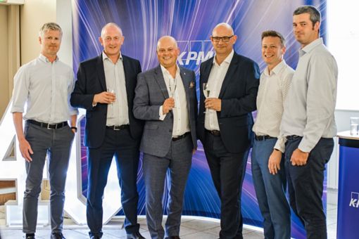 6 men stood in front of purple banner