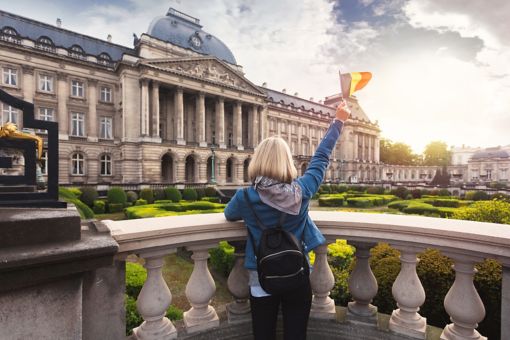 Woman waiving Belgian flag in front of royal palace