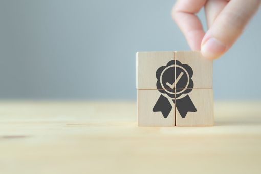 Wooden tiles visualizing a certification ribbon