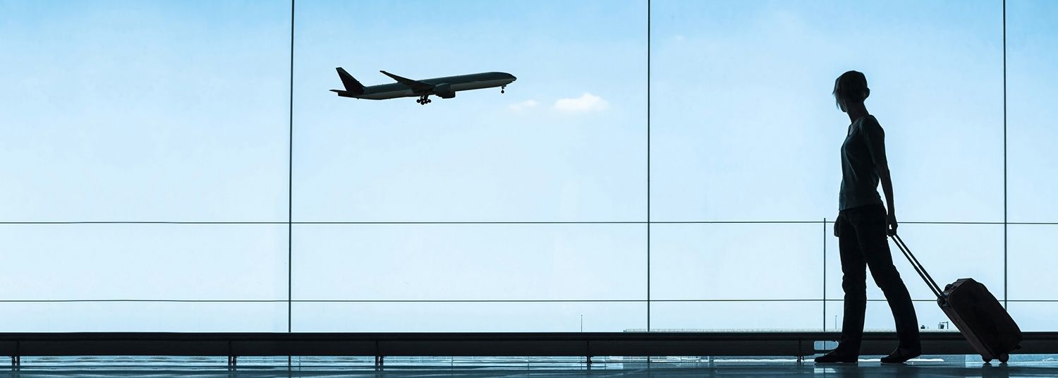 Business woman with suitcase walking through airport