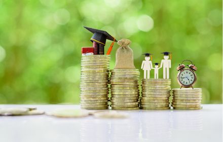 Een stapel munten die staan voor opleiding, salaris, gezin en privé-tijd