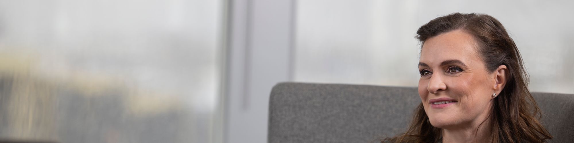 Starfsmaður KPMG Law situr og brosir út um glugga