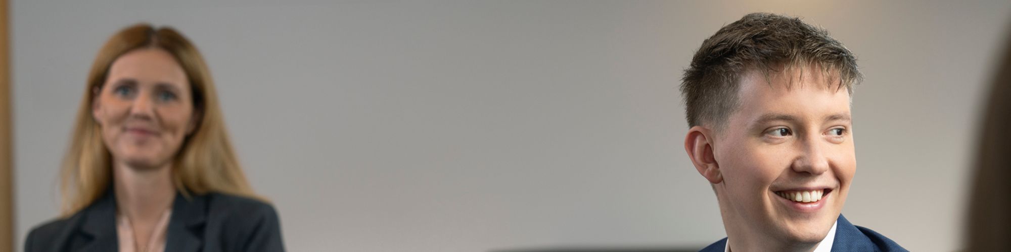 Starfsmaður KPMG Law situr og brosir út um glugga