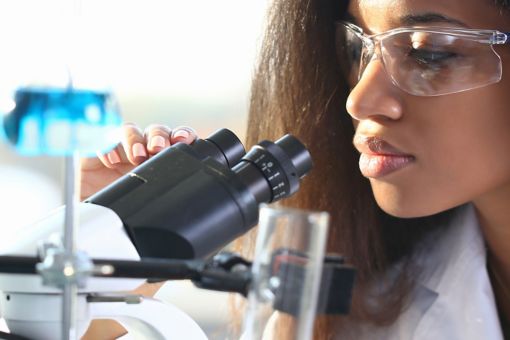 Female scientist looking through microscope