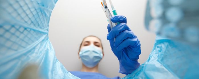 Woman in mask throwing away medical needles