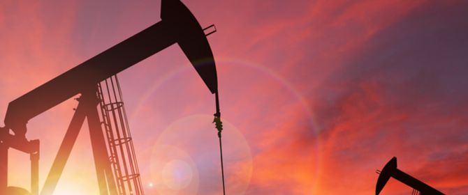 imagem de duas máquinas de mineração escavando a terra e o céu está alaranjado de fim de tarde