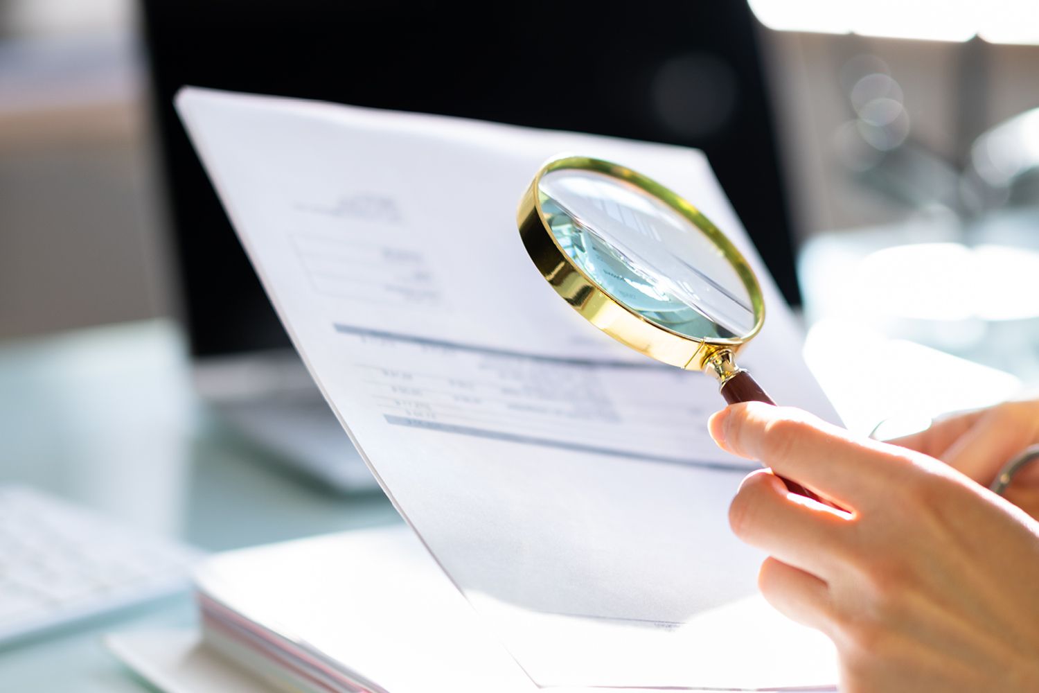 Magnifying glass above a pay slip