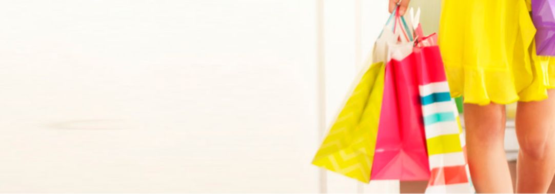 KPMG IFRS revenue topic image: Woman in a yellow dress carrying colourful shopping bags