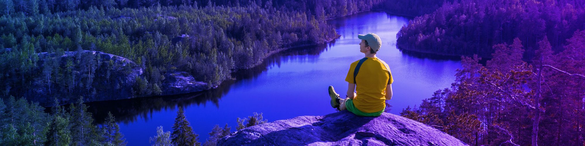 Man on cliff looking at landscape