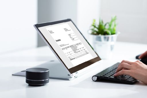 person putting invoice in bookkeeping on laptop